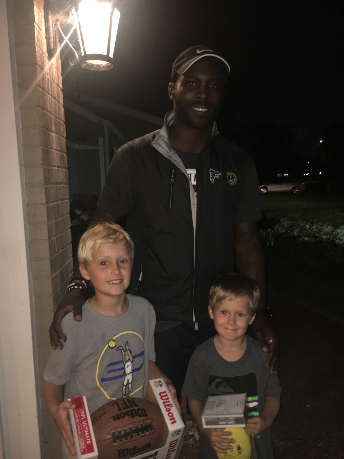 Michael Vick with Brody and Bentley holding signed footballs at their home