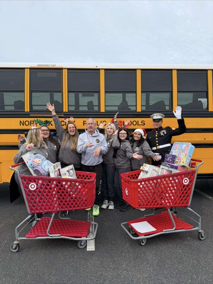 Stuff the Bus volunteers and a Marine with carts full of toys