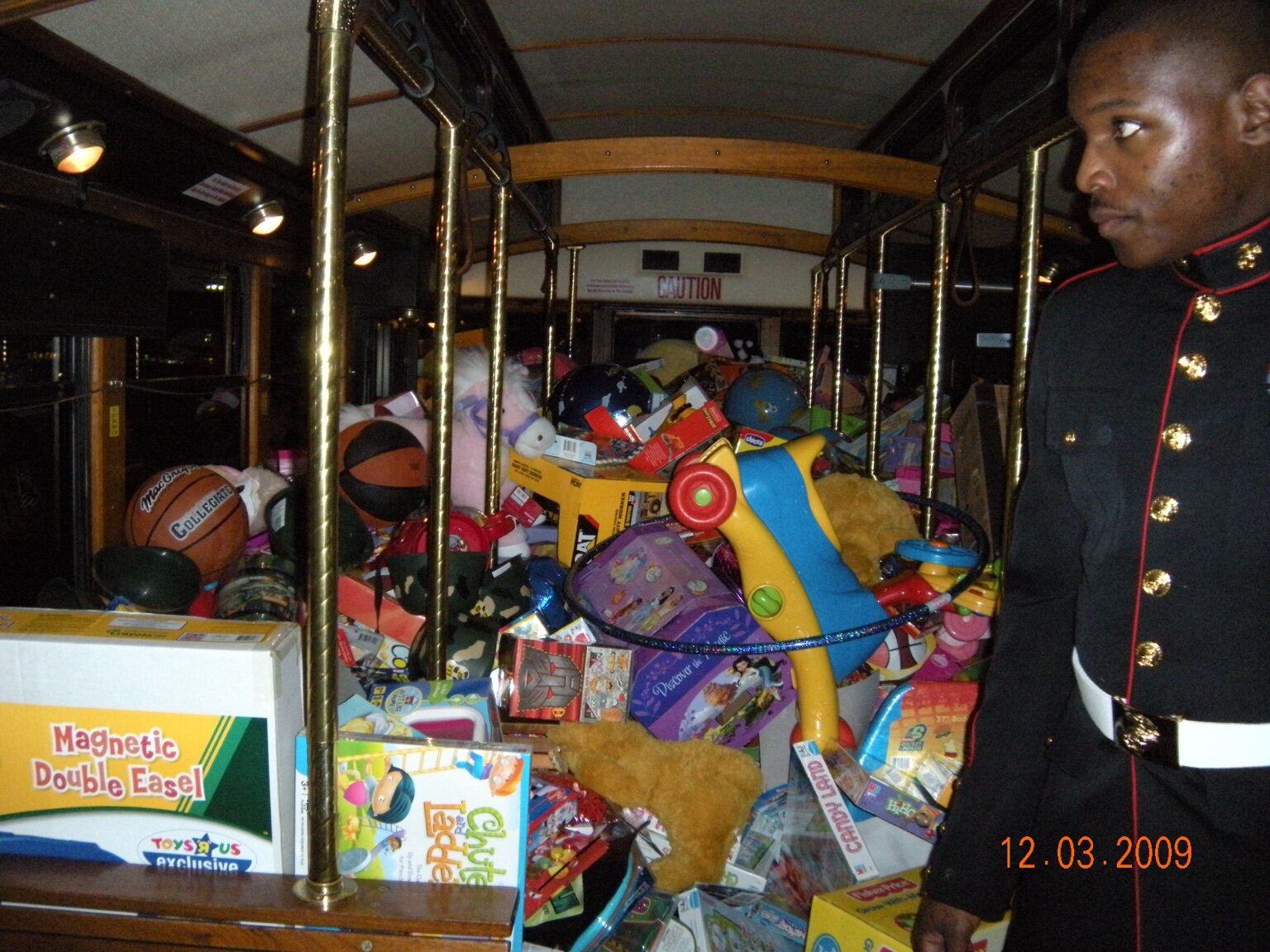 A Marine beside a toy-filled bus during the early years of Stuff the Bus