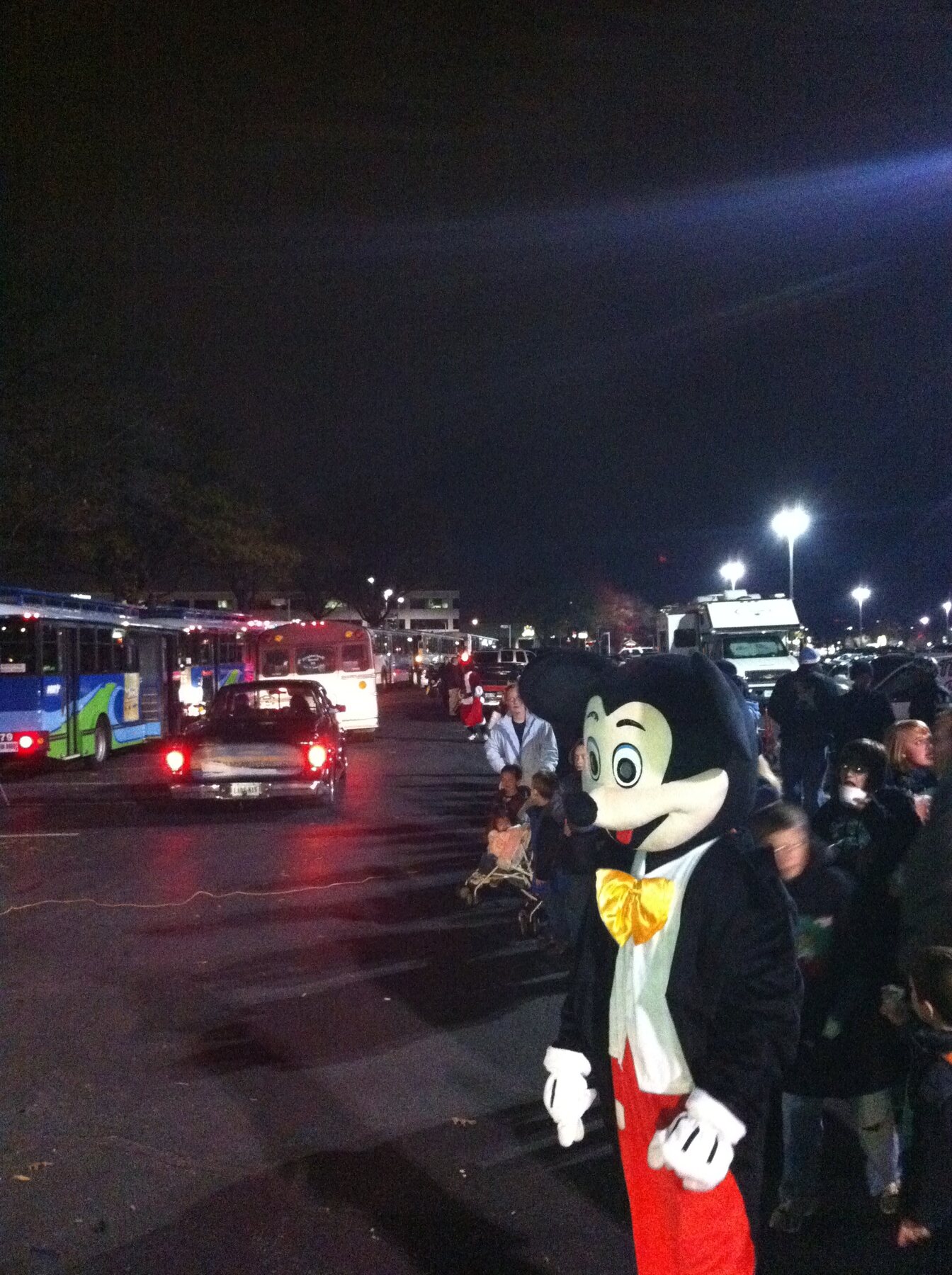 A Mickey Mouse character greeting people outside Stuff the Bus at night in 2010