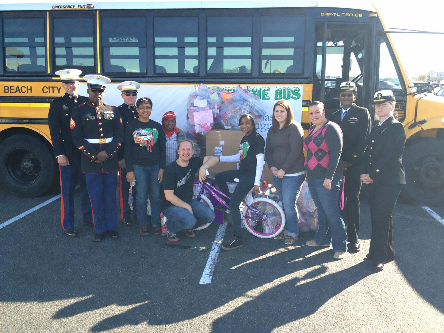 Marines, Navy personnel and volunteers with donated toys at Stuff the Bus in 2011